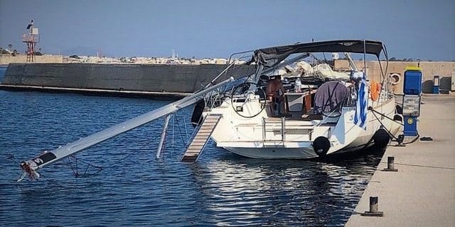 Ein Segelboot liegt im Wasser in der Nähe eines Docks.